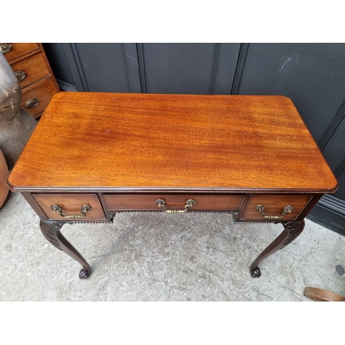 1043 - An early 20th century mahogany kneehole side table, on cabriole legs with scroll feet, 90cm wide.... 