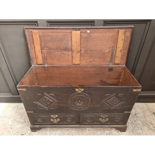 1054 - An 18th century carved oak mule chest, 118cm wide.