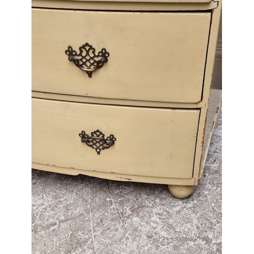 1003 - An old cream painted bowfront chest of drawers, 99.5cm wide.