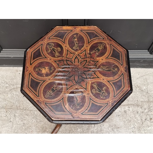 1016 - A 19th century ebonized octagonal tilt-top tripod table, with stencilled decoration, 48cm wide.... 