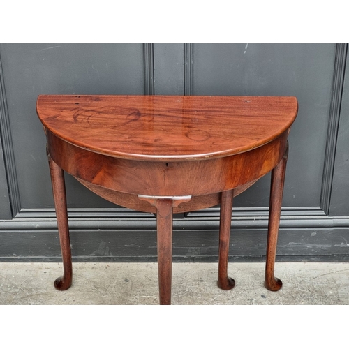 1020 - A mahogany demi-lune drop leaf table, with hinged top and single gateleg, 76cm wide.... 