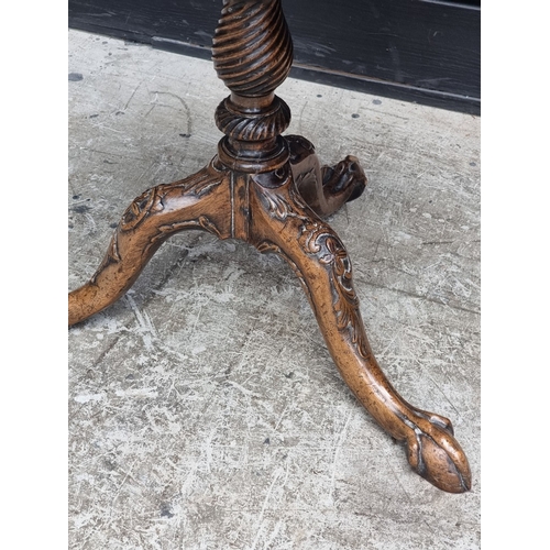 1049 - An 18th century style carved walnut low tripod table, 51.5cm high x 52.5cm diameter.... 