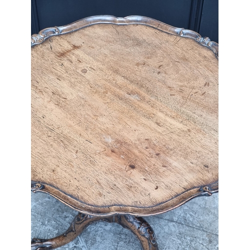 1049 - An 18th century style carved walnut low tripod table, 51.5cm high x 52.5cm diameter.... 