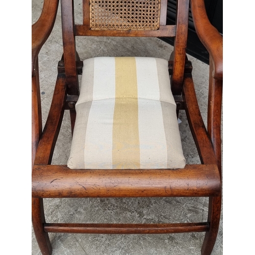 1055 - A late Victorian mahogany and beech folding steamer chair, with cane back.
