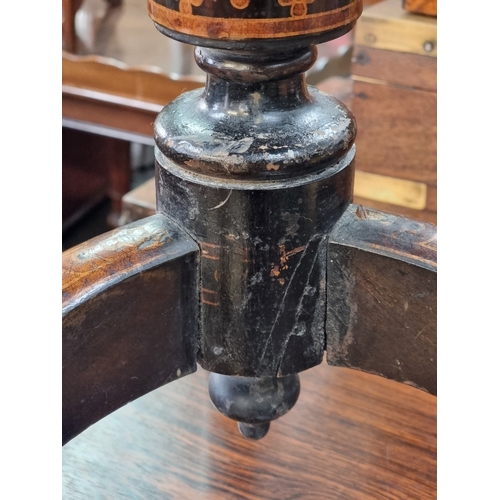 1019 - A 19th century ebonized octagonal tilt-top tripod table, with stencilled decoration, 48cm wide.... 