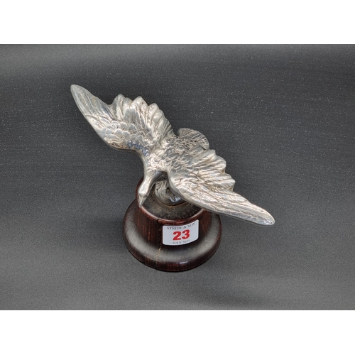 23 - A vintage chrome plated Eagle car mascot, wingspan 19.5cm, on turned wood socle.