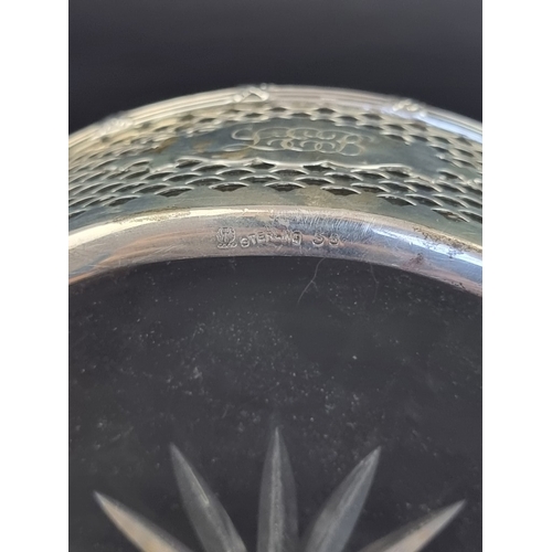 209 - A white metal swing handled basket, with glass liner, stamped 'Sterling', 17cm diameter.... 