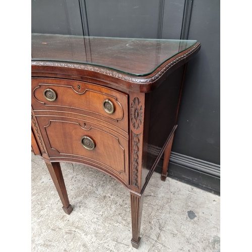 1046 - A late George III carved mahogany serpentine fronted sideboard, 182cm wide.