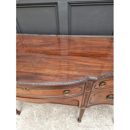 1046 - A late George III carved mahogany serpentine fronted sideboard, 182cm wide.