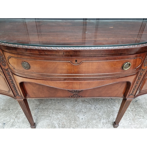 1046 - A late George III carved mahogany serpentine fronted sideboard, 182cm wide.