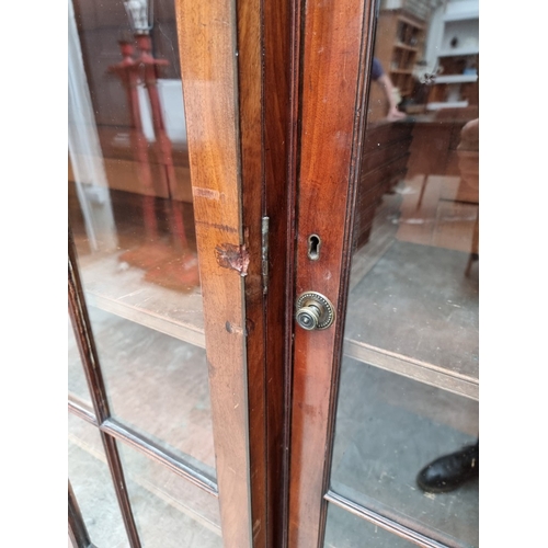 1051 - A large early 19th century mahogany and ebony strung breakfront bookcase, 195cm wide.... 