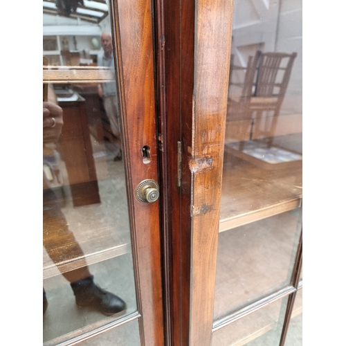 1051 - A large early 19th century mahogany and ebony strung breakfront bookcase, 195cm wide.... 