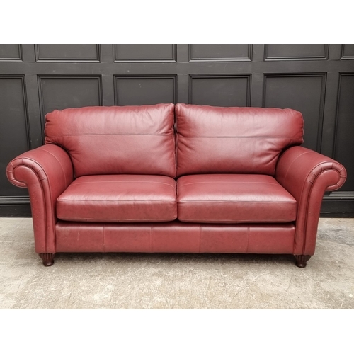 1053 - A red leather settee, from Multiyork, 205cm wide.