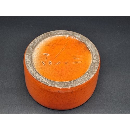 1332 - Studio Pottery: a George Jouve orange glazed box and cover, 10cm high.