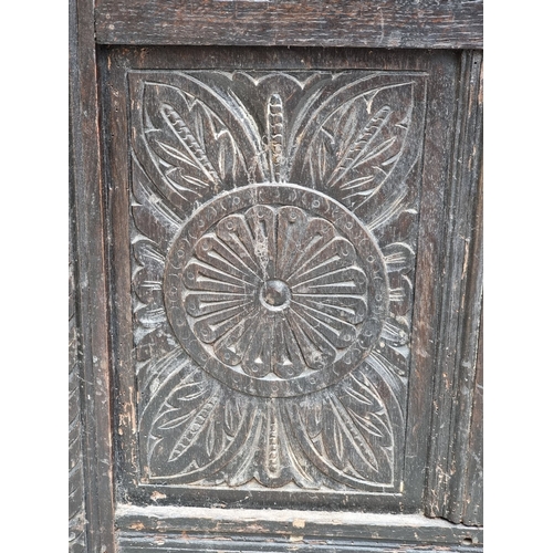 1023 - A late 17th century carved oak panelled coffer, 145cm wide.