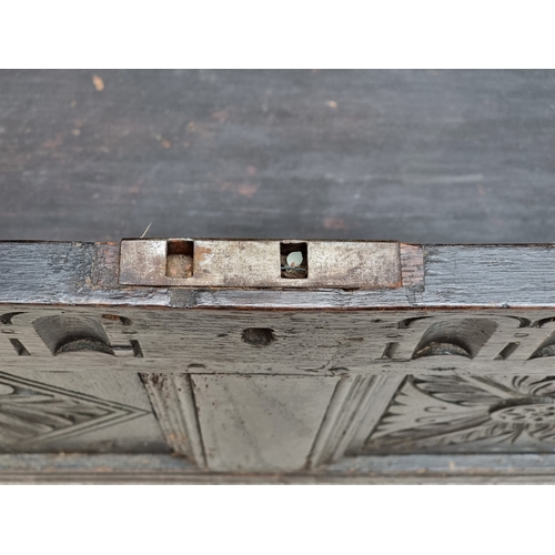 1023 - A late 17th century carved oak panelled coffer, 145cm wide.