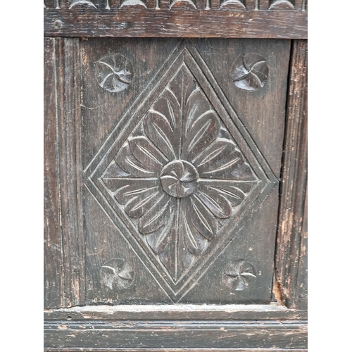 1023 - A late 17th century carved oak panelled coffer, 145cm wide.