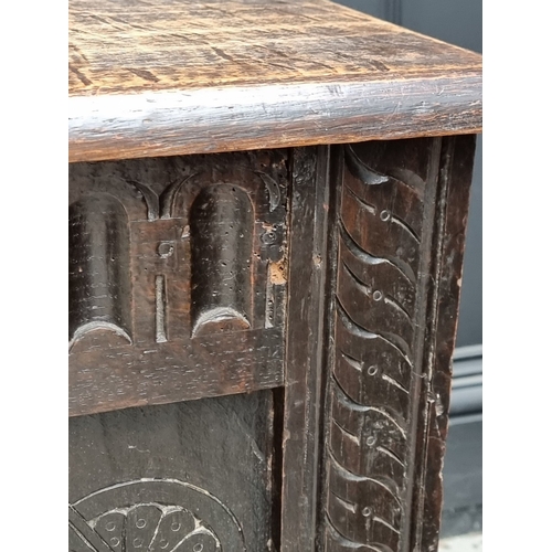 1023 - A late 17th century carved oak panelled coffer, 145cm wide.