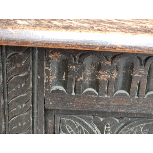 1023 - A late 17th century carved oak panelled coffer, 145cm wide.