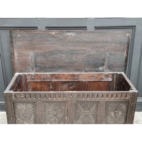 1023 - A late 17th century carved oak panelled coffer, 145cm wide.