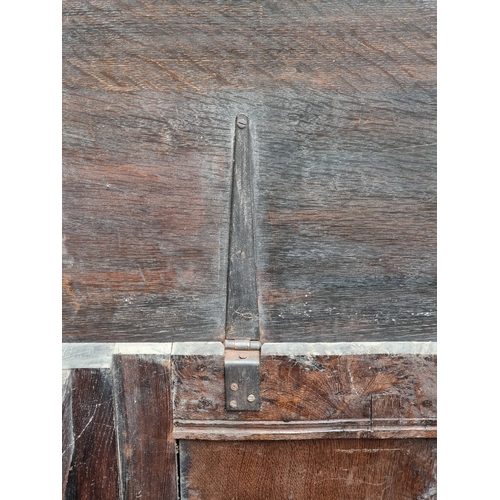 1023 - A late 17th century carved oak panelled coffer, 145cm wide.