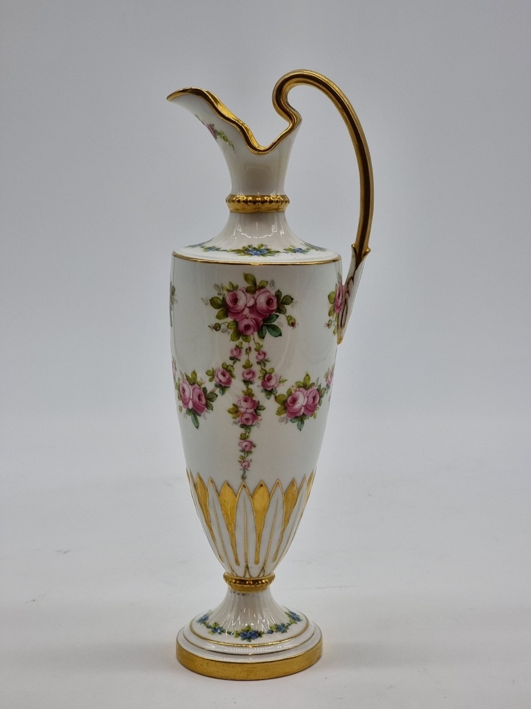 A Mintons porcelain ewer, painted with swags and festoons of pink roses ...