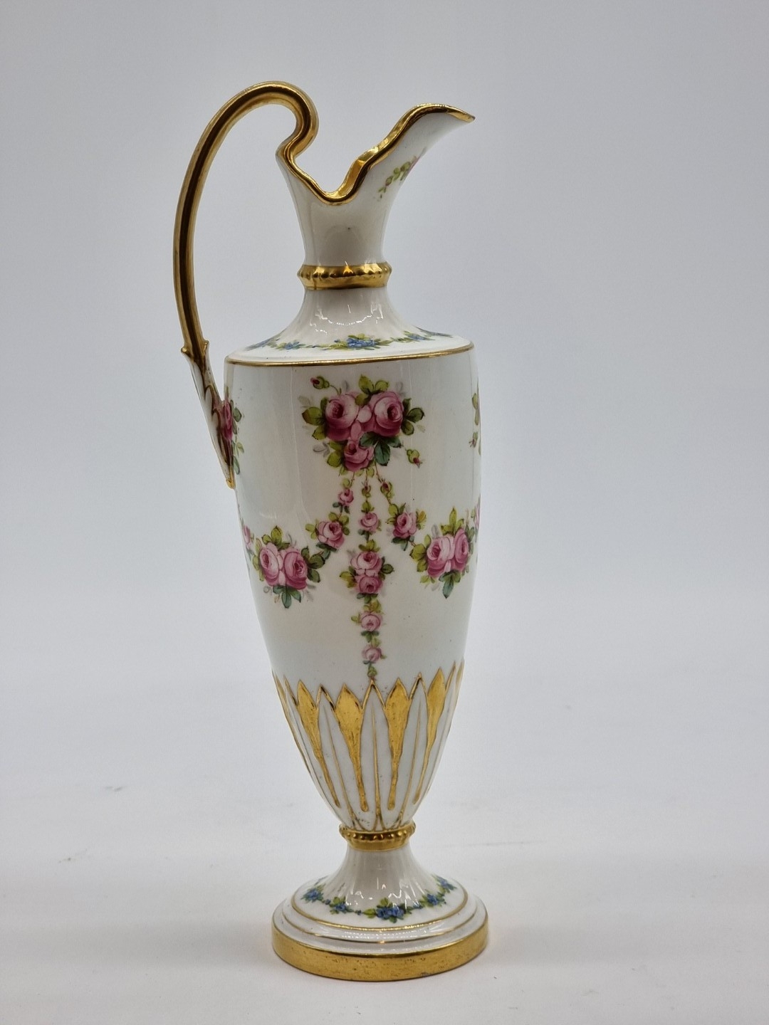 A Mintons porcelain ewer, painted with swags and festoons of pink roses ...