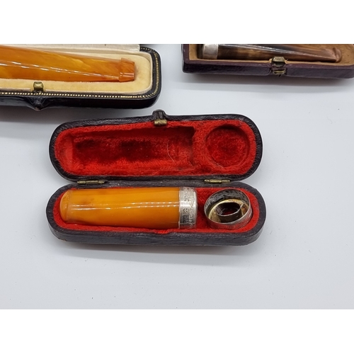 Five vintage boxed cheroot holders, to include amber examples, two with ...