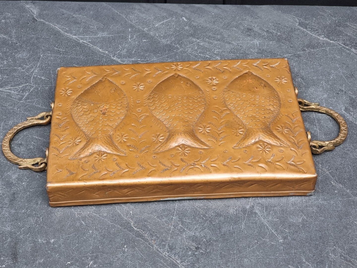 A Newlyn copper twin handled tray, repousse decorated with fish, 32cm ...
