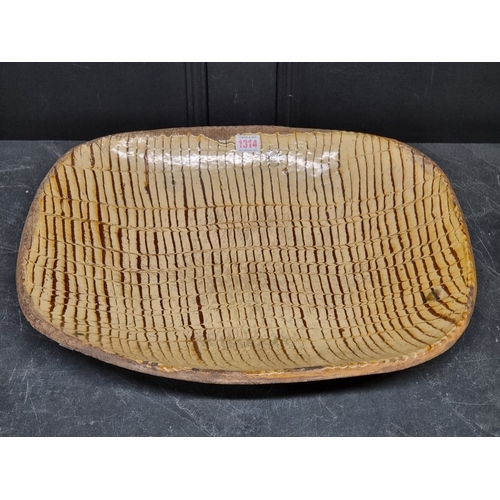 1314 - A good and large antique slipware dish, possibly Isleworth, with combed decoration, 52cm wide.... 