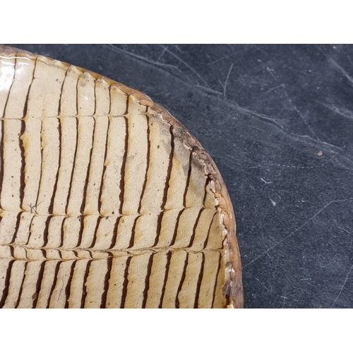 1314 - A good and large antique slipware dish, possibly Isleworth, with combed decoration, 52cm wide.... 