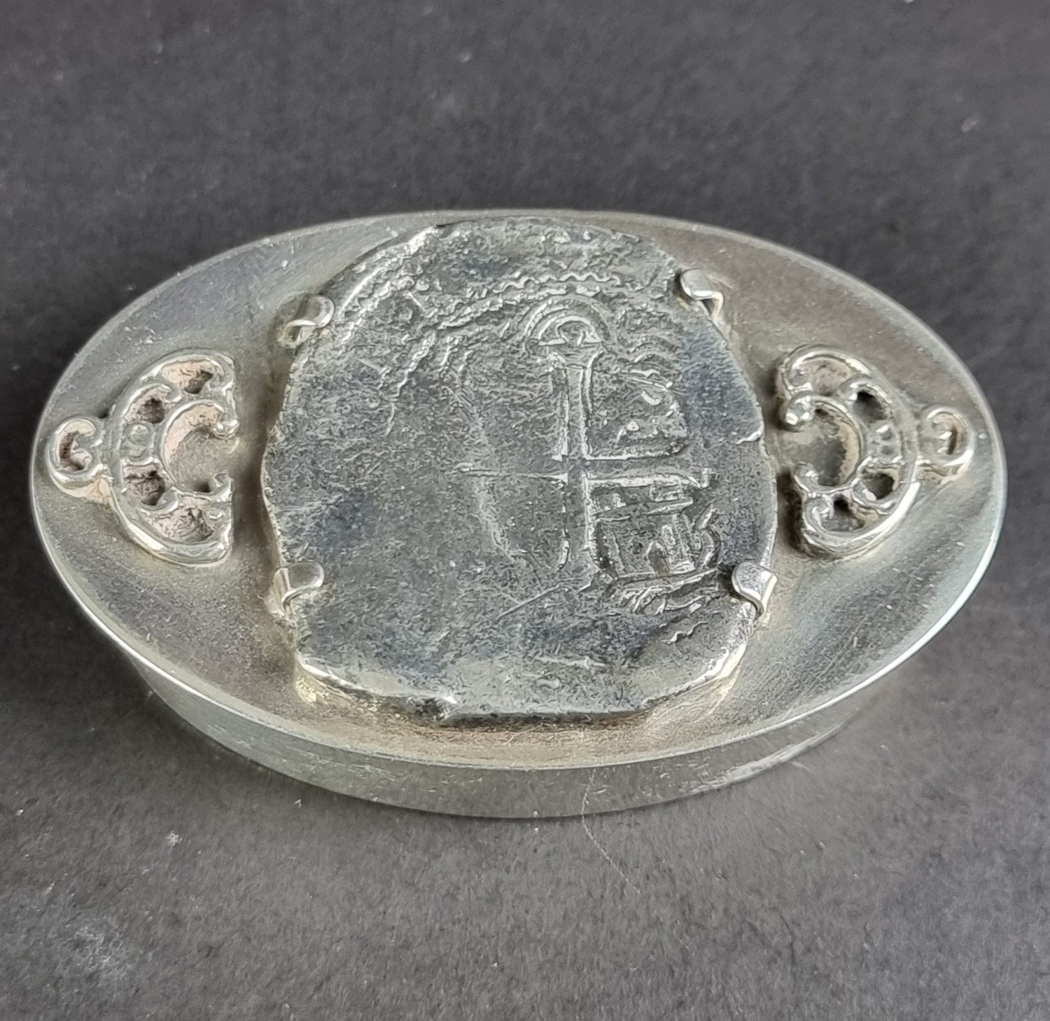 A white metal box, inset Spanish hammered coin, stamped with swan mark ...