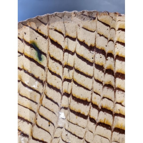 1314 - A good and large antique slipware dish, possibly Isleworth, with combed decoration, 52cm wide.... 