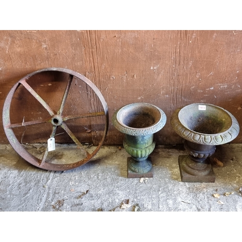 1413 - Two small cast iron Campana urns, largest 31cm high; together with a cast iron six-spoke wheel, 48cm... 