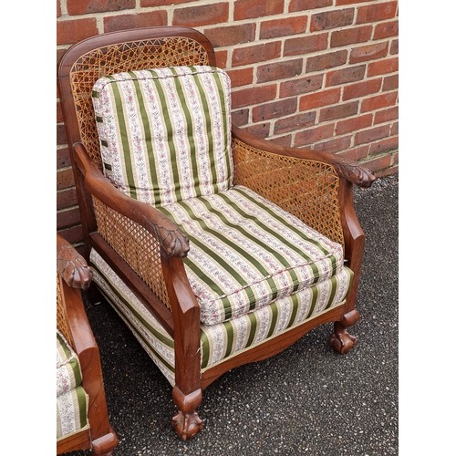 1069 - A pair of 1930s walnut and cane bergere chairs, with cushions.