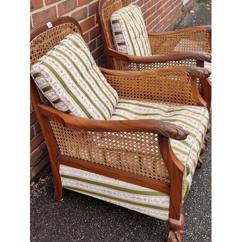 1069 - A pair of 1930s walnut and cane bergere chairs, with cushions.