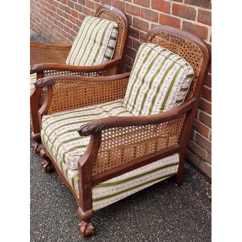 1069 - A pair of 1930s walnut and cane bergere chairs, with cushions.