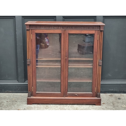 1047 - A late Victorian mahogany bookcase, with blind fret frieze and turned pilasters, 104.5cm wide.... 