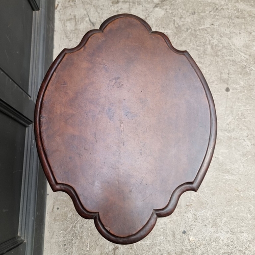 1060 - A 19th century carved walnut tilt-top tripod table, of shaped outline, 58cm wide, (old repair to leg... 