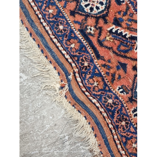 1010 - A Persian rug, having repeated design to central field, with floral and geometric borders, 188 x 142... 