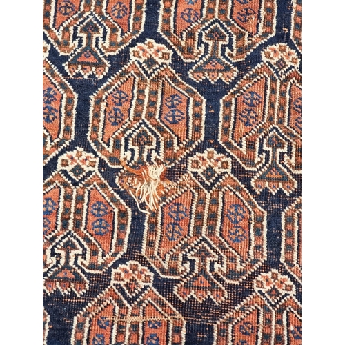 1010 - A Persian rug, having repeated design to central field, with floral and geometric borders, 188 x 142... 