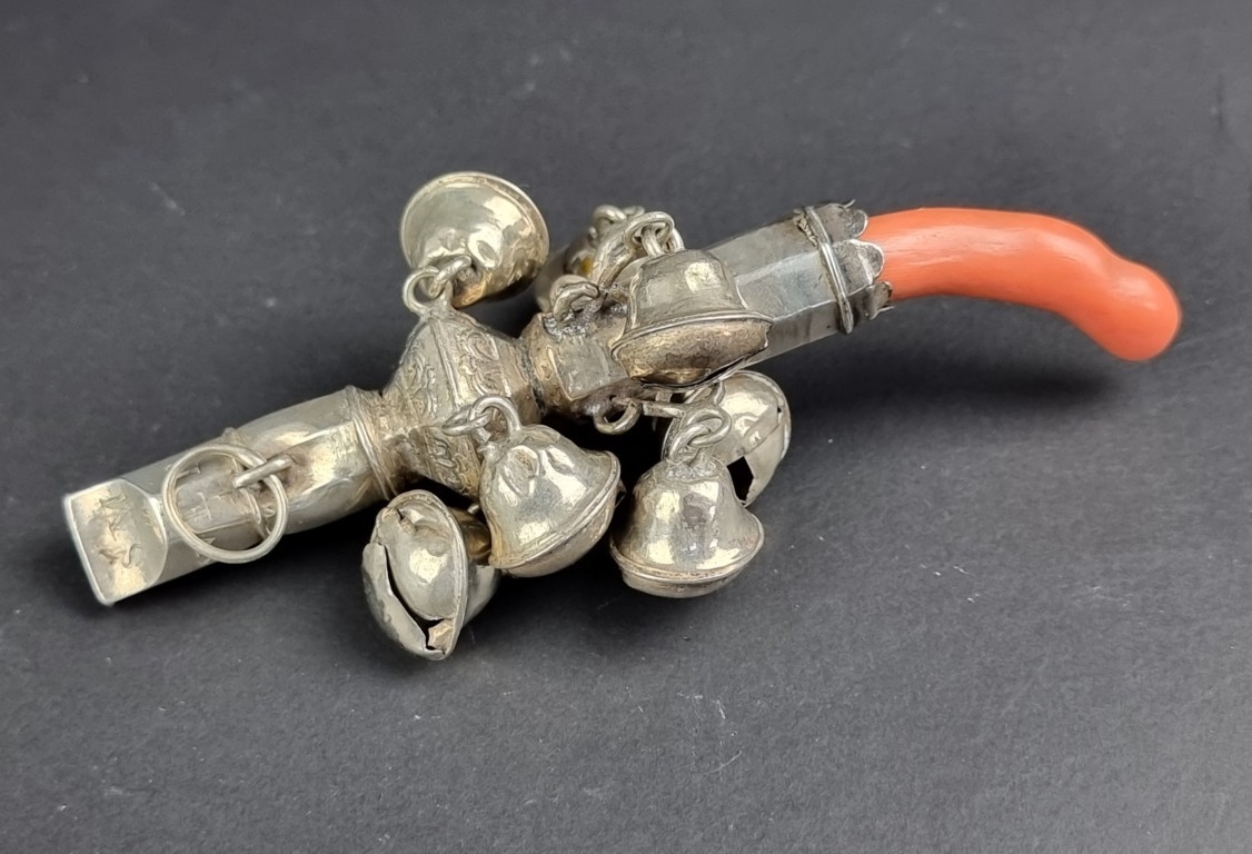 A coral handled silver rattle, marks rubbed, 11.5cm long, (s.d.).