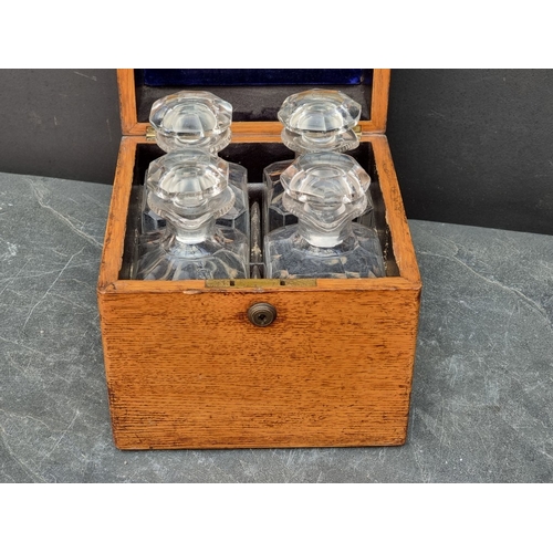 1151 - A Victorian oak decanter box, enclosing four lipped clear glass decanters and stoppers, (one decante... 