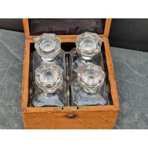 1151 - A Victorian oak decanter box, enclosing four lipped clear glass decanters and stoppers, (one decante... 