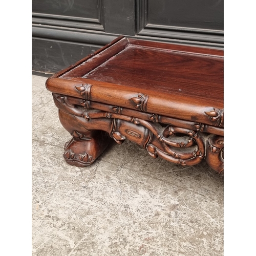 1023 - A Chinese carved hardwood low stand or table, 97cm wide.