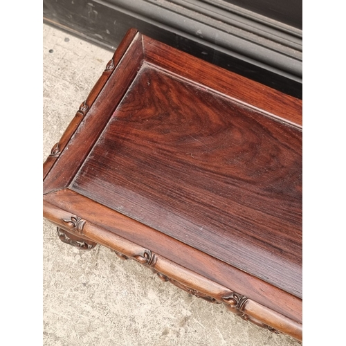 1023 - A Chinese carved hardwood low stand or table, 97cm wide.