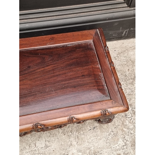 1023 - A Chinese carved hardwood low stand or table, 97cm wide.