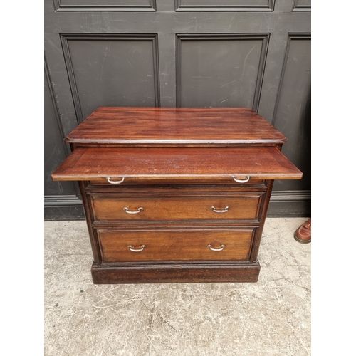 1031 - A vintage stained teak three drawer chest, with brushing slide, the back edge of one drawer inscribe... 