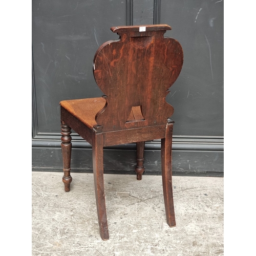 1058 - A late George III oak hall chair, (split to seat).