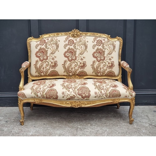 1072 - A Louis XV style carved giltwood and upholstered salon suite, comprising: a settee, 132cm wide; a pa... 